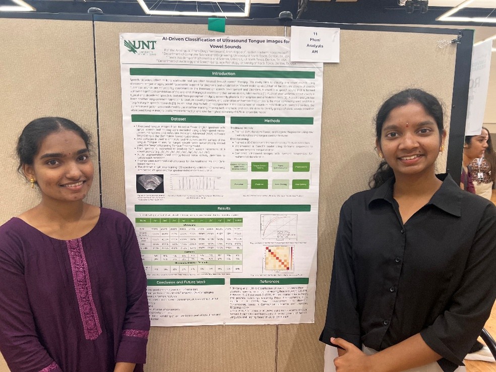 Two graduates students standing by a research poster