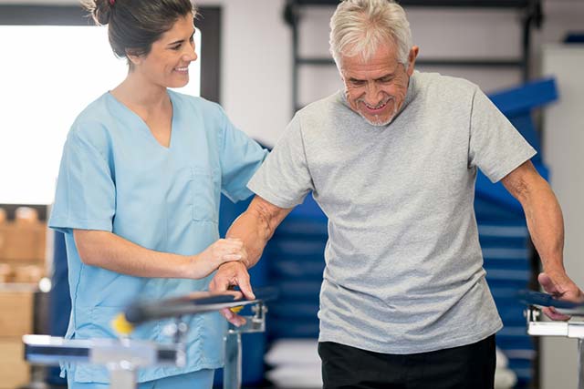 Woman helping a man with physical therapy