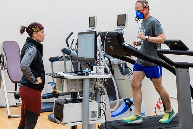 Woman working with a man on a treadmill