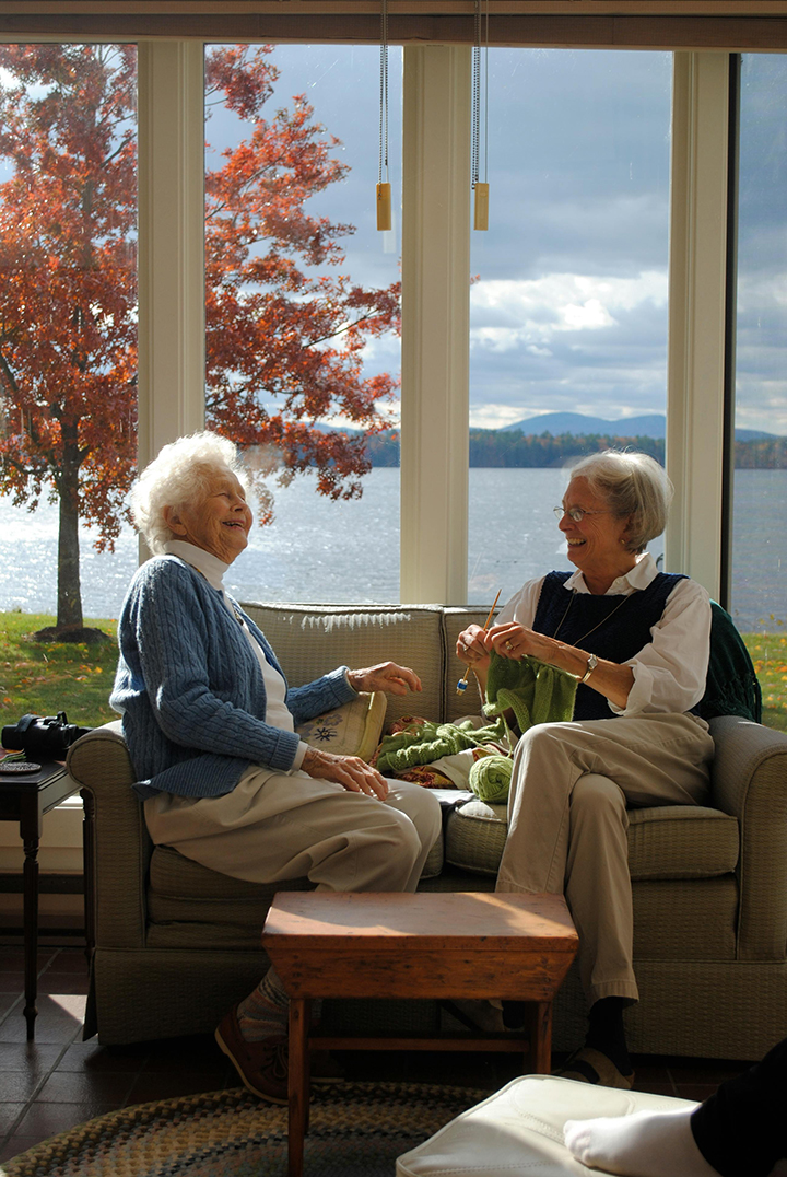 Two active senior women sitting on a couch talking