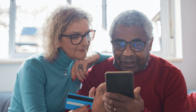 An active senior male and female looking at a smart phone