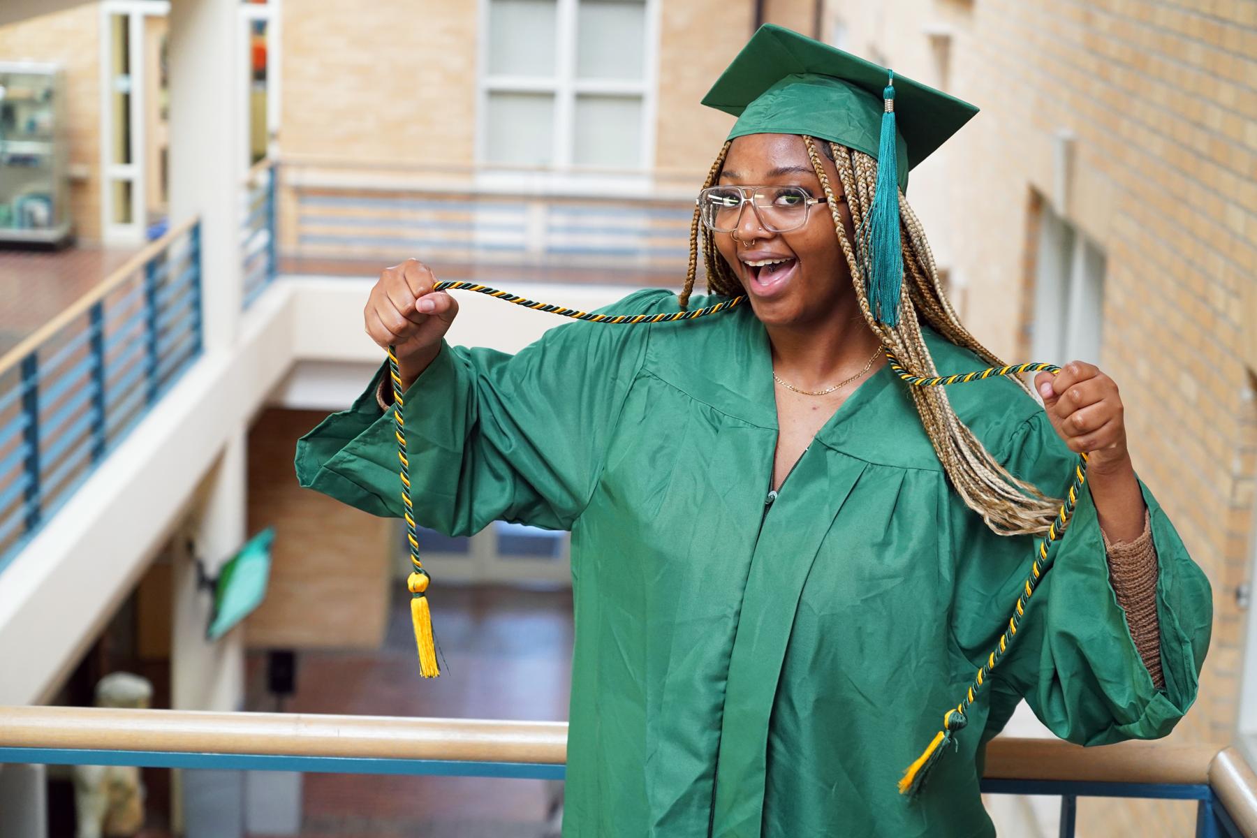 Happy graduate showing off philanthropy cord