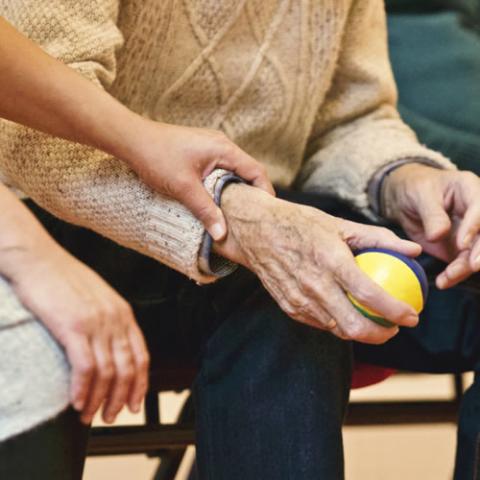 Woman's hand holding the arm of an older man