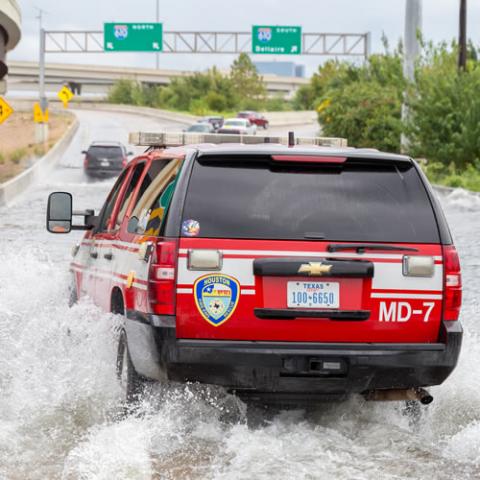 Emergency vehicle driving through flood waters