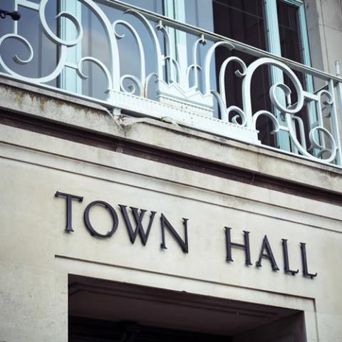 Front of a town hall with a sign that says Town Hall