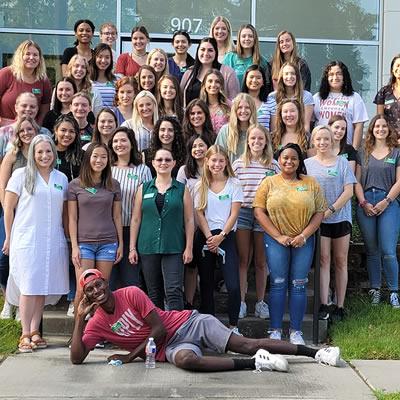 SLP graduates standing together on the steps of the UNT Speech & Hearing Center