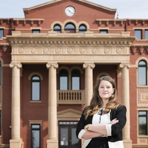 City employee standing in front of a city hall building