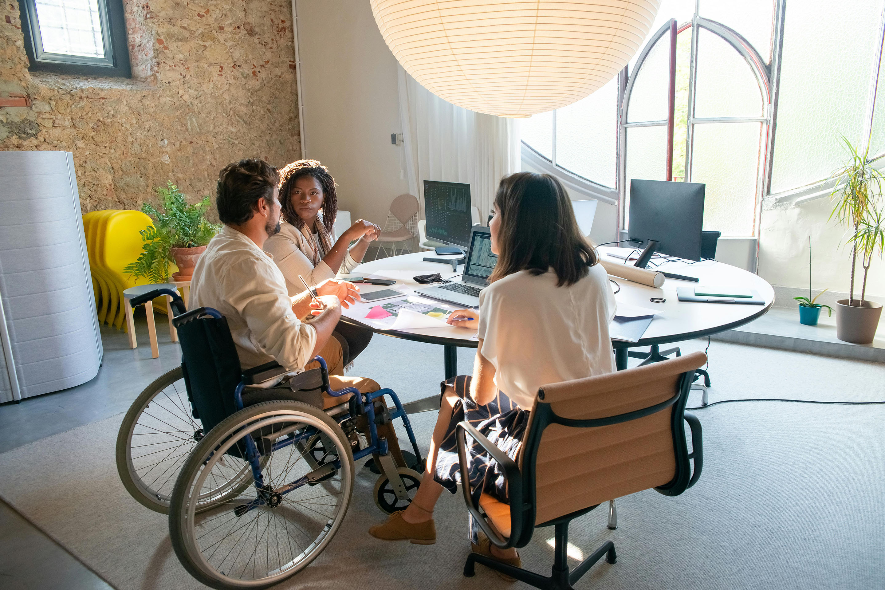 Man in wheelchair working with counselors